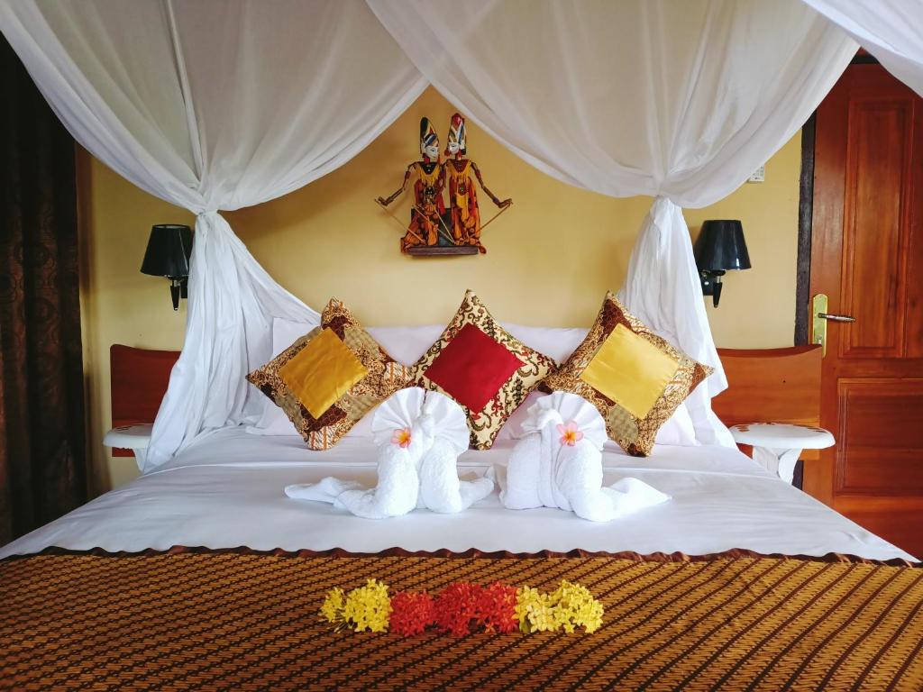 a bed with two stuffed animals on top of it at Tangkoko Sanctuary Villa in Bitung