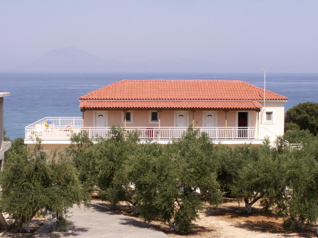 a house with a lot of trees in front of the ocean at Kastro Beach Hotel in Kyllini
