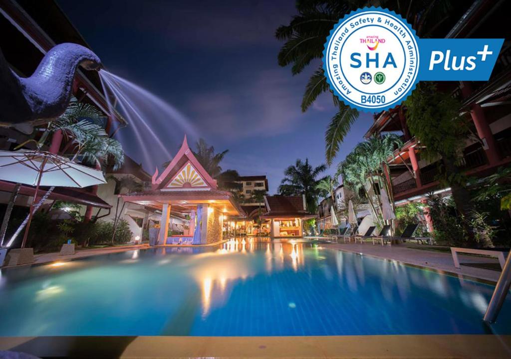 a hotel swimming pool at night with a sign that reads sla plus at Sai Rougn Residence - SHA Extra Plus in Patong Beach