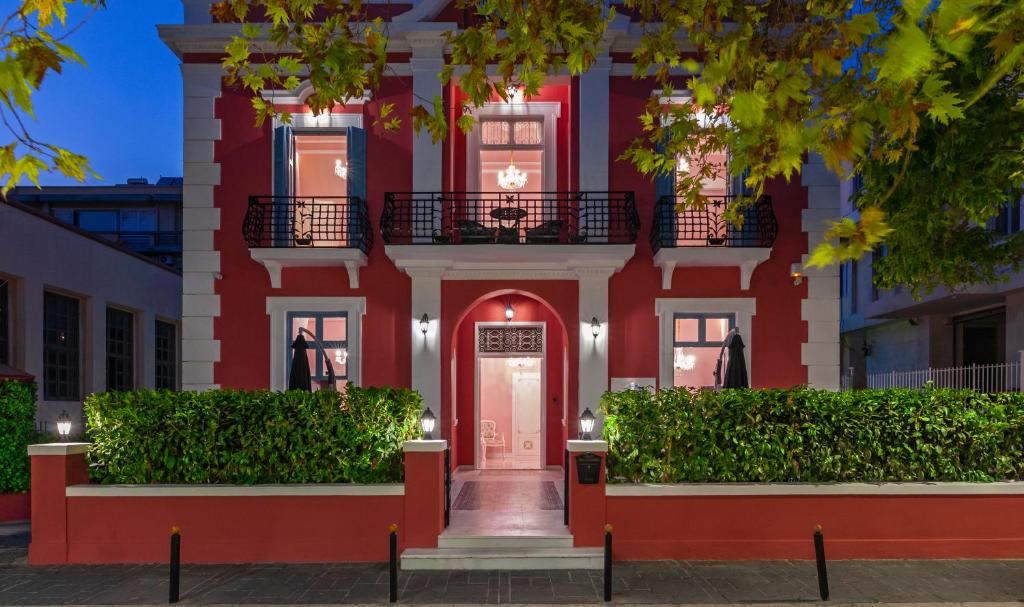 een rood gebouw met een rode deur en struiken bij Via Villa Iliotti Rhodos in Rhodos-stad