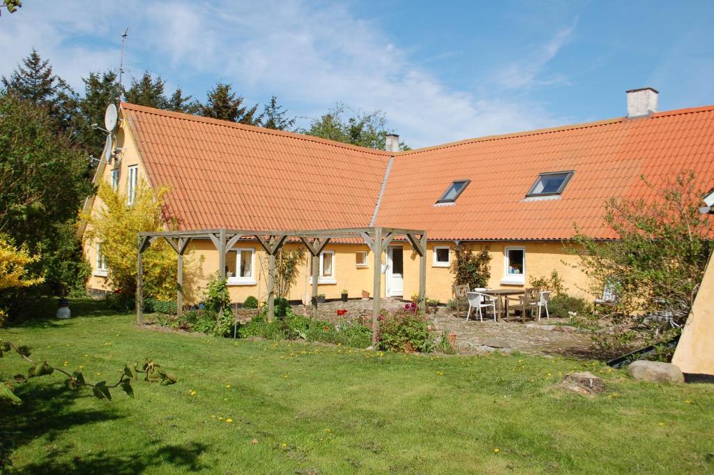 una casa con techo naranja y patio en Engbjerg BnB, en Hirtshals