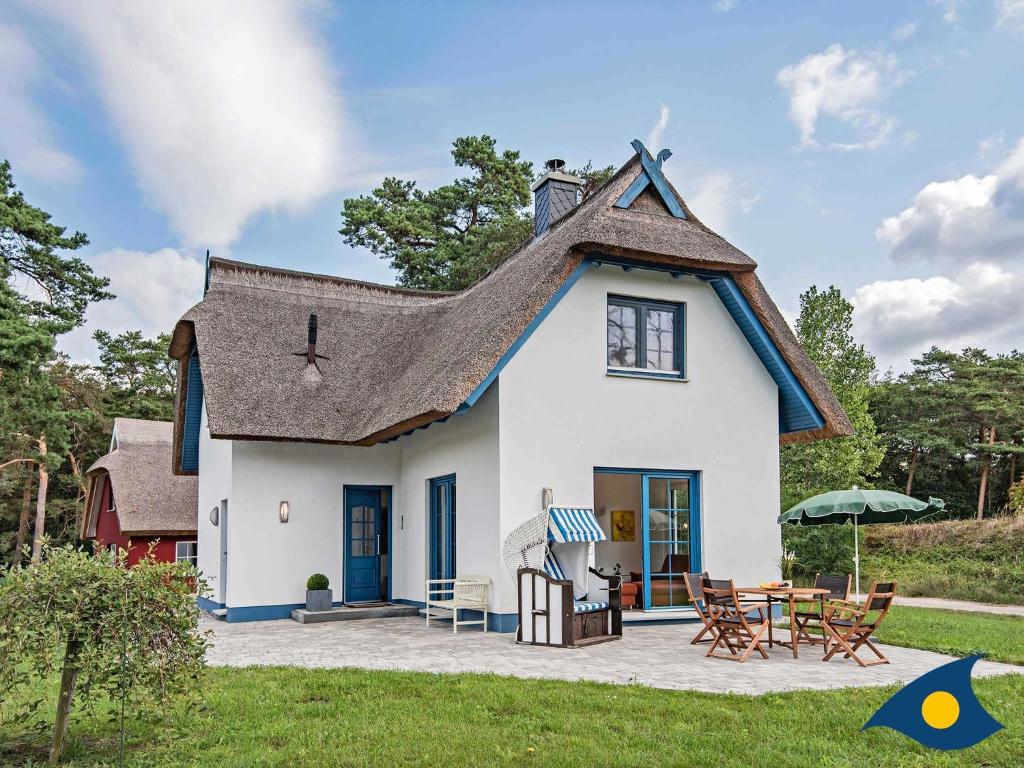 a small white house with a gambrel roof at Fischerdorf Zirchow Käptn 12 B in Zirchow