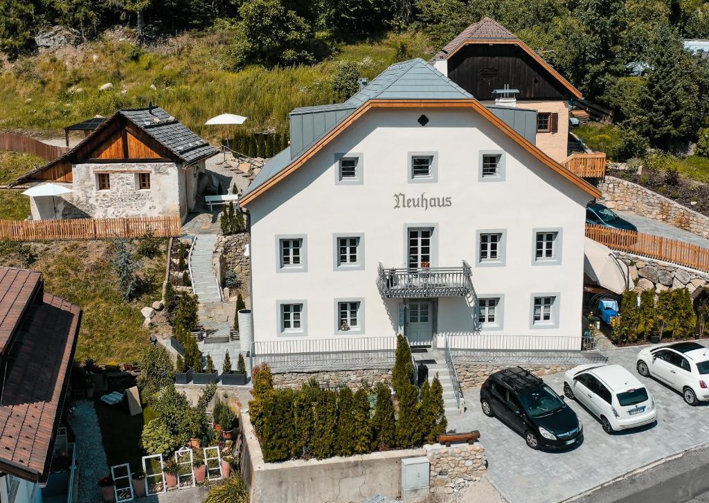 an aerial view of a white house with cars parked in a parking lot at Apartment, historic Chalet & Guest House Neuhaus in San Sigismondo