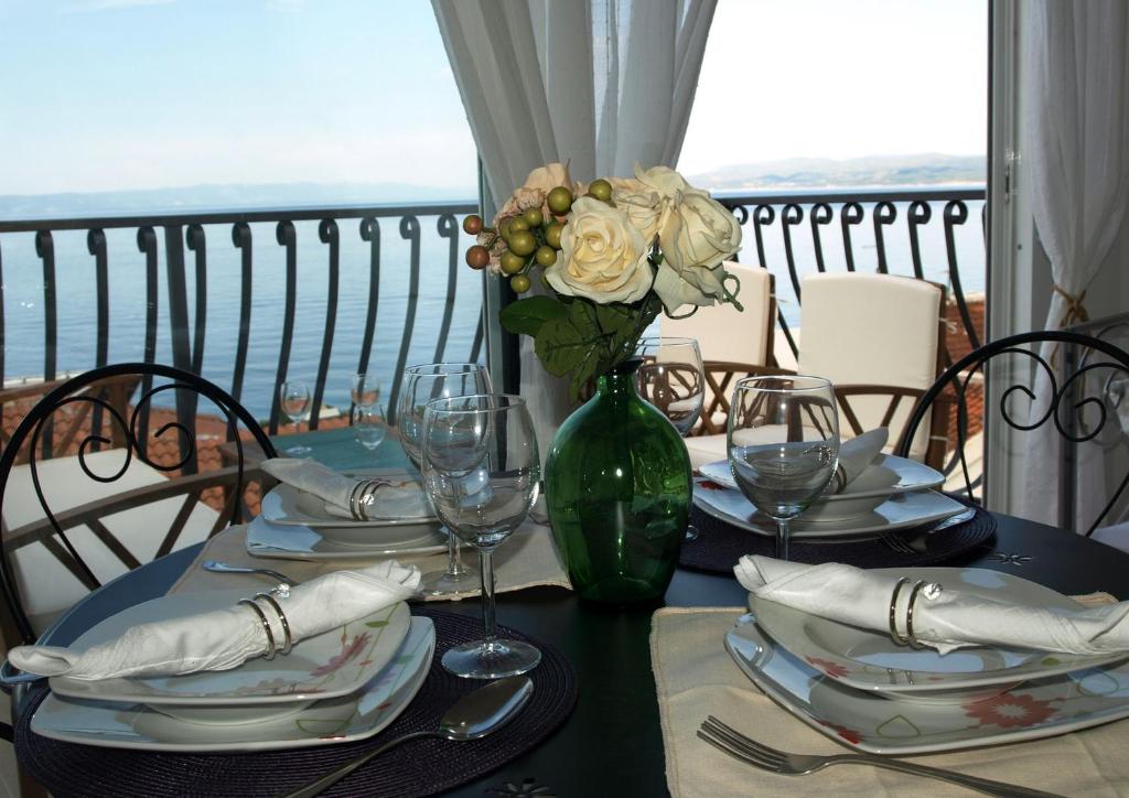 una mesa con platos y un jarrón con flores. en Apartments Issa, en Makarska