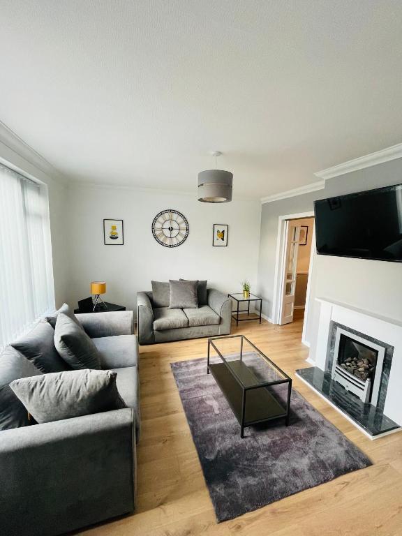 a living room with a couch and a fireplace at Wolverhampton Large 3 Bedroom 5 bed House Perfect for Contractors Short & Long Stays Business NHS Families Sleeps up to 5 people Private Garden Driveway for 2 large Vehicles Close to City Centre M6 M54 and Walsall Willenhall Cannock in Wolverhampton