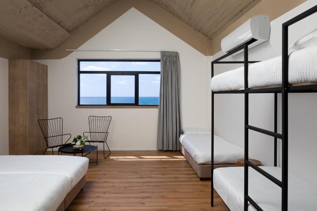 1 Schlafzimmer mit 2 Etagenbetten und einem Fenster in der Unterkunft 180 Boutique Hostel in Tel Aviv