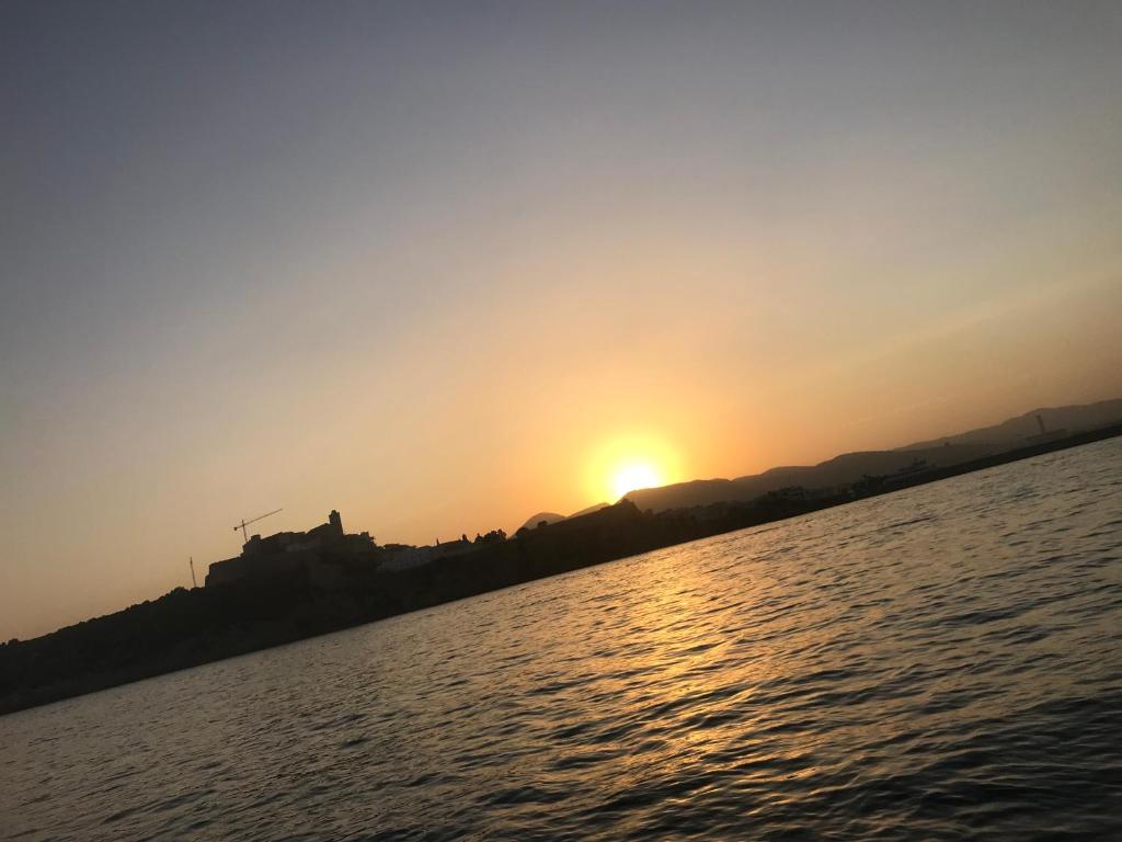 einen Sonnenuntergang am Ufer eines Wasserkörpers in der Unterkunft Can Lovers in Sant Jordi
