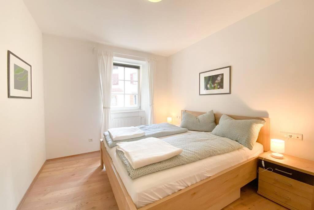 a bedroom with a bed and a window at In Urbi, city appartement in Bressanone