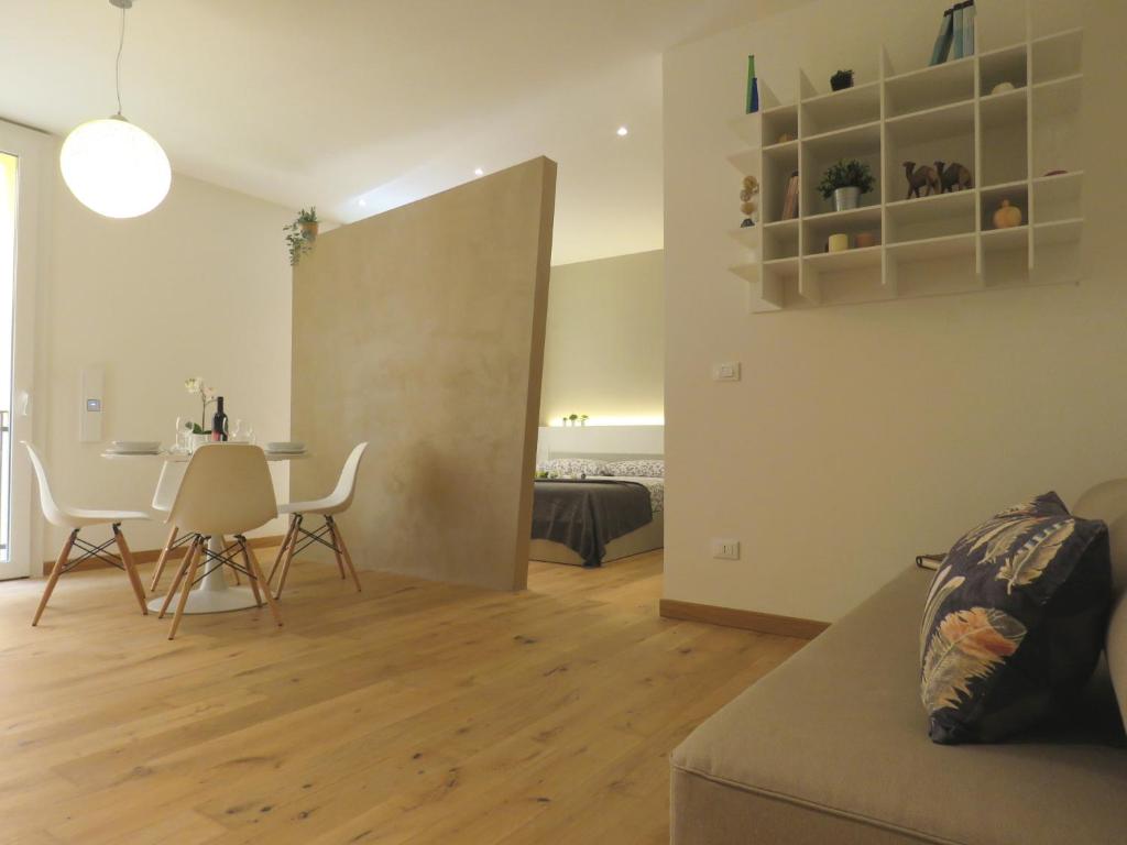 uma sala de estar com um sofá e uma mesa com cadeiras em Ariosti Apartment em Bolonha