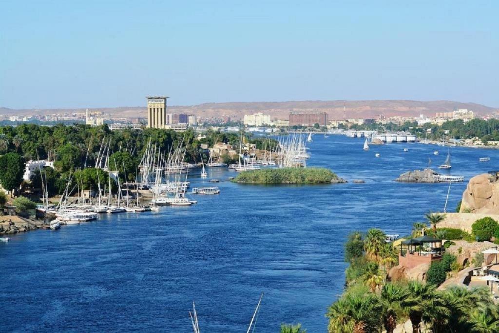a view of a river with boats in it at Taharka Nubian House in Aswan