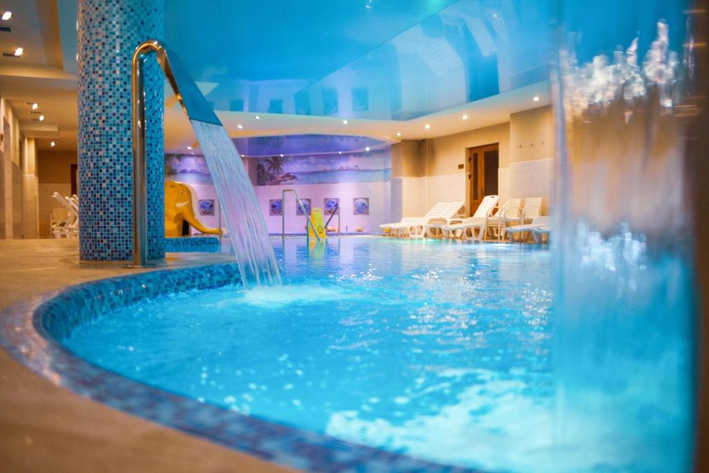 una piscina en un hotel con un tobogán de agua en Romantik Spa Hotel, en Yaremche