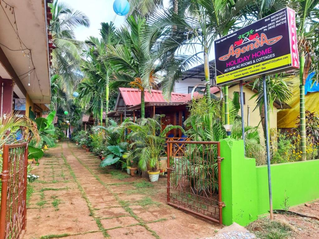 a building with a sign and a bunch of plants at Agonda Holiday Home in Agonda