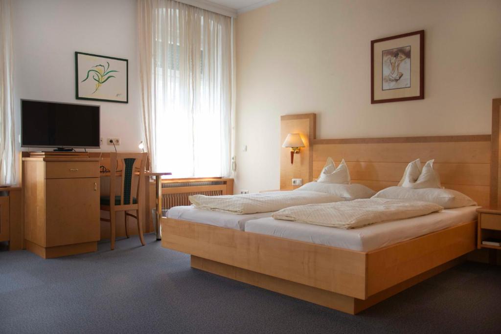 Schlafzimmer mit einem Bett und einem Flachbild-TV in der Unterkunft Fleger Appartements in Wien