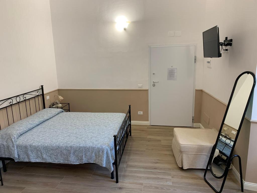 una camera con letto, sedia e televisore di DOMUS L’AUREA a La Spezia