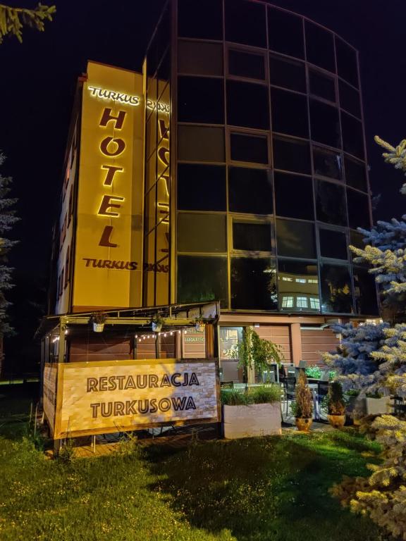 a building with a sign in front of it at Hotel Turkus in Jarosław