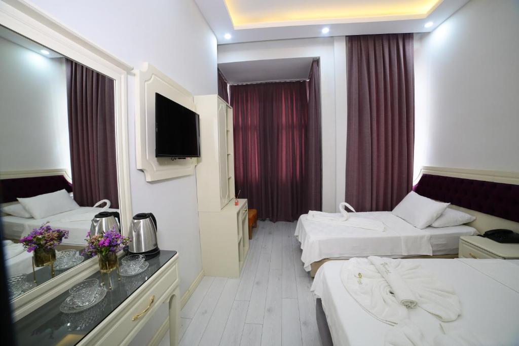 a hotel room with two beds and a television at taksim diamond hotel in Istanbul