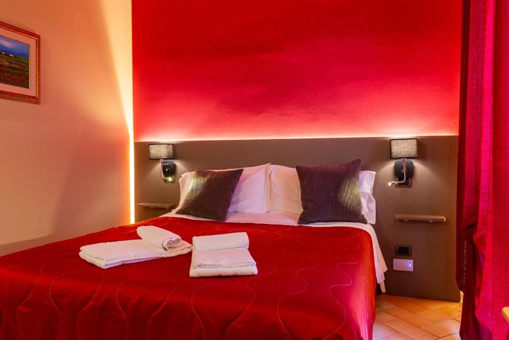 a red bedroom with a bed with two towels on it at Agriturismo AgrileisureTime in Spoleto