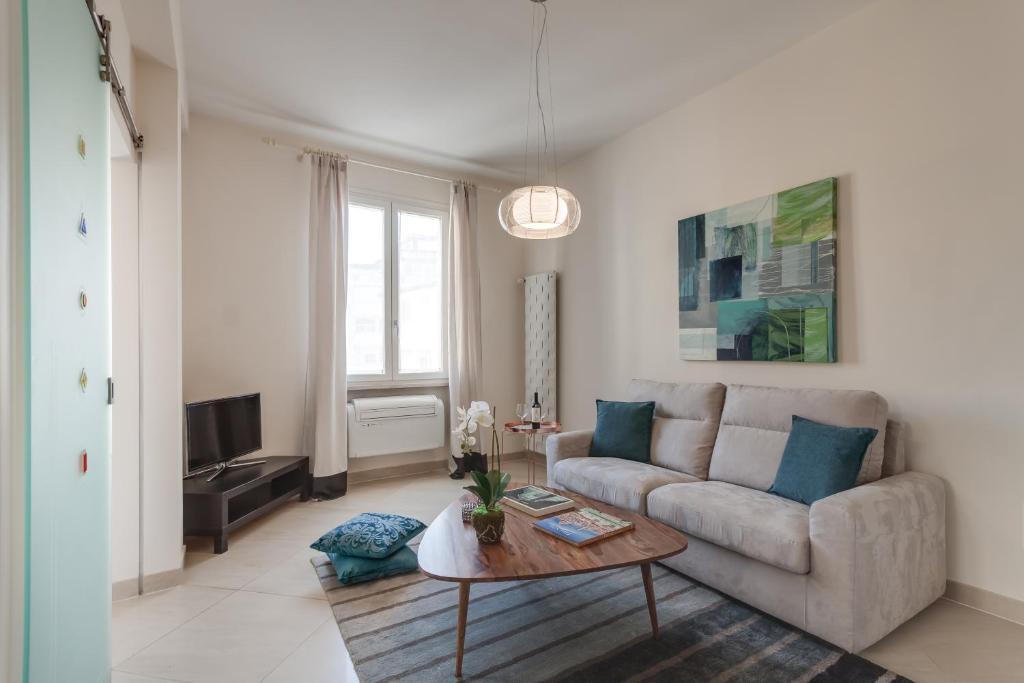 een woonkamer met een bank en een tafel bij Apartments Florence - Oriuolo Elegance in Florence