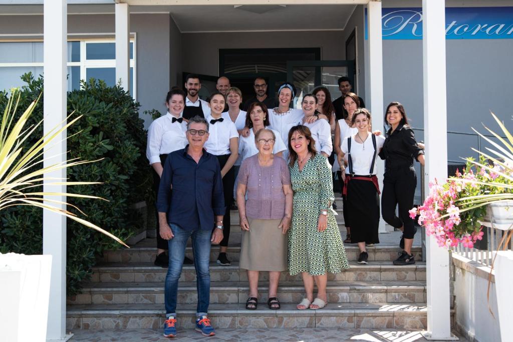 een groep mensen die op de trappen van een huis staan bij Hotel Umberto in Rosolina Mare