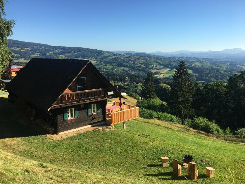 a wooden house on a hill with a green field at Ferienhaus Trausibauer in Stainz