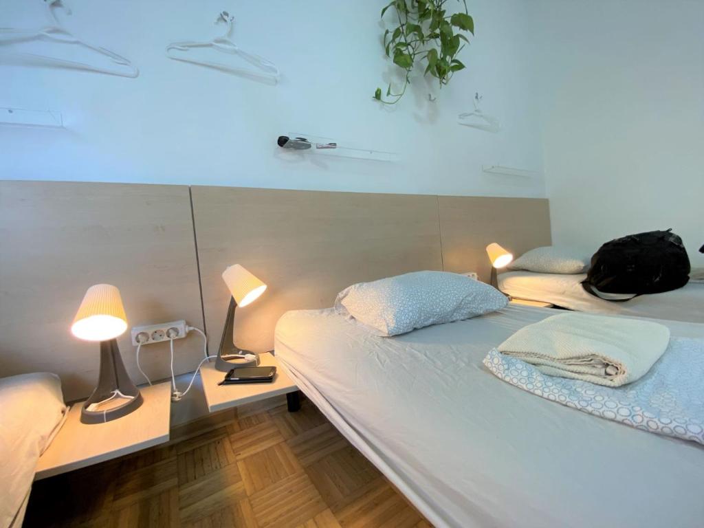 a room with a bed with two lamps and a phone at Guesthouse GreenSLO in Ljubljana