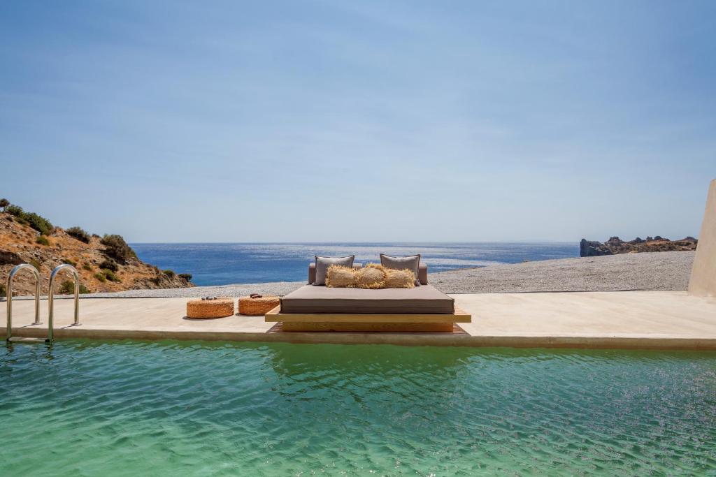 a swimming pool with a view of the ocean at Altera cave villas in Agios Pavlos