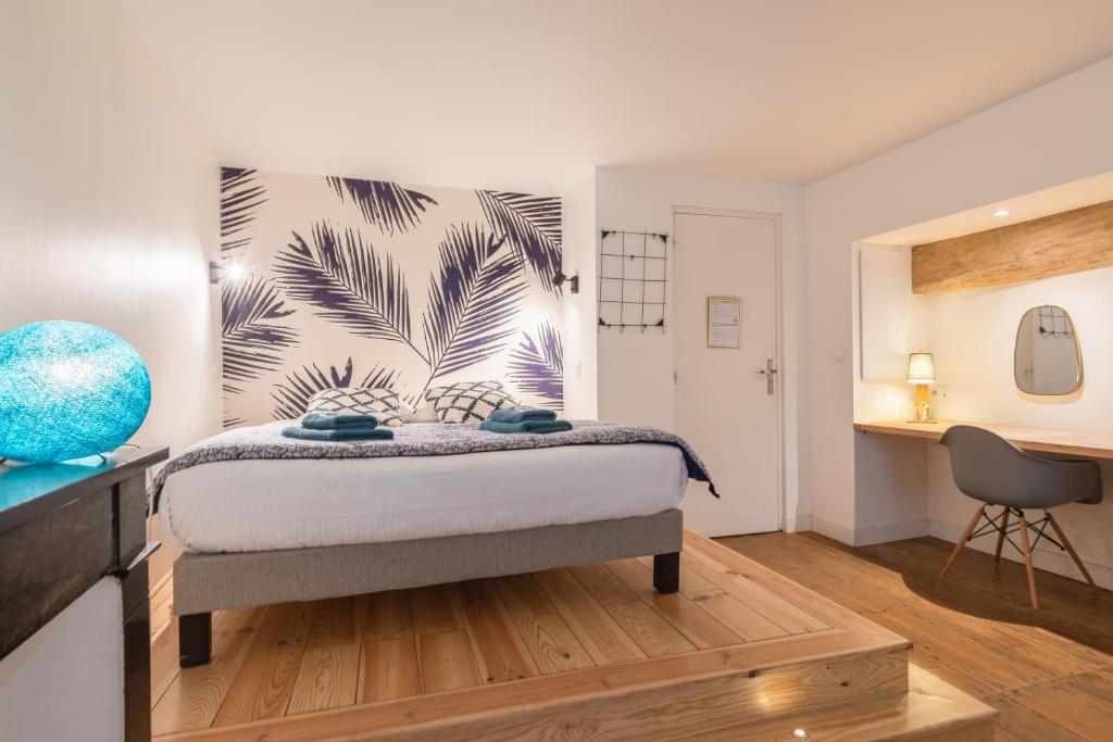 a bedroom with a bed and a desk at Gabylou in Bordeaux
