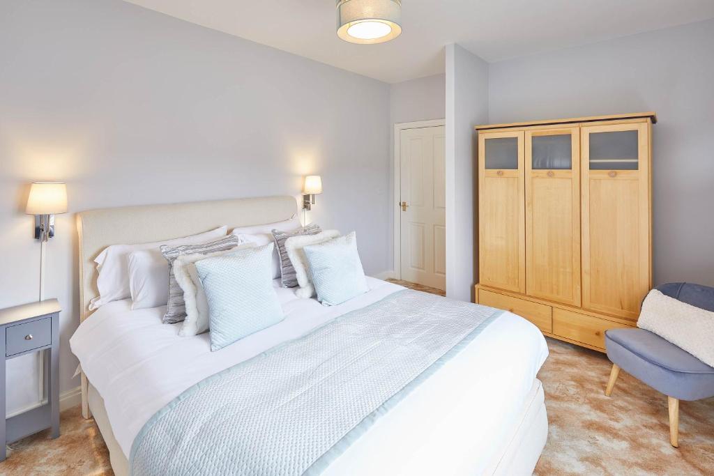 een slaapkamer met een groot wit bed en een blauwe stoel bij Host & Stay - Starboard Bow in Whitby