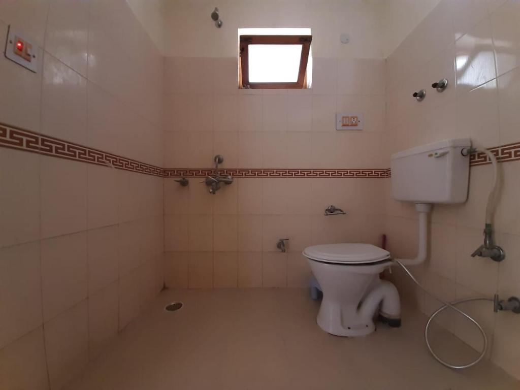 bagno con servizi igienici bianchi e finestra di Rabyang Guest House and Homestay a Leh