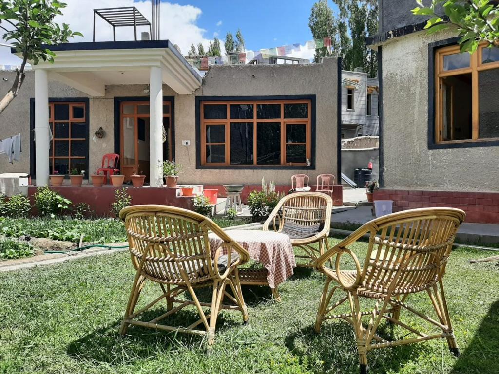 3 sedie e un tavolo di fronte a una casa di Rabyang Guest House and Homestay a Leh
