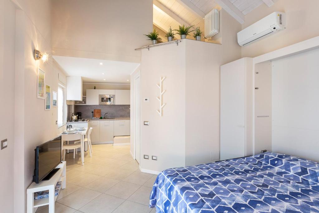 Cet appartement comprend une chambre avec un lit et une cuisine. dans l'établissement COME A CASA 19 - Romantic Studio, à Massino Visconti