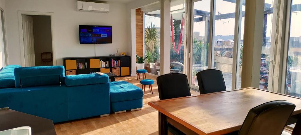 a living room with a blue couch and a table at 110 sq.m. stunning Penthouse with large terrace in St Paul's Bay