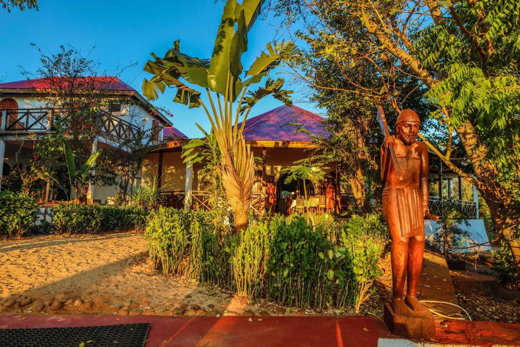 Eine Statue eines Mannes, der vor einem Haus steht. in der Unterkunft OLYMPE DE BEMARAHA in Bekopaka