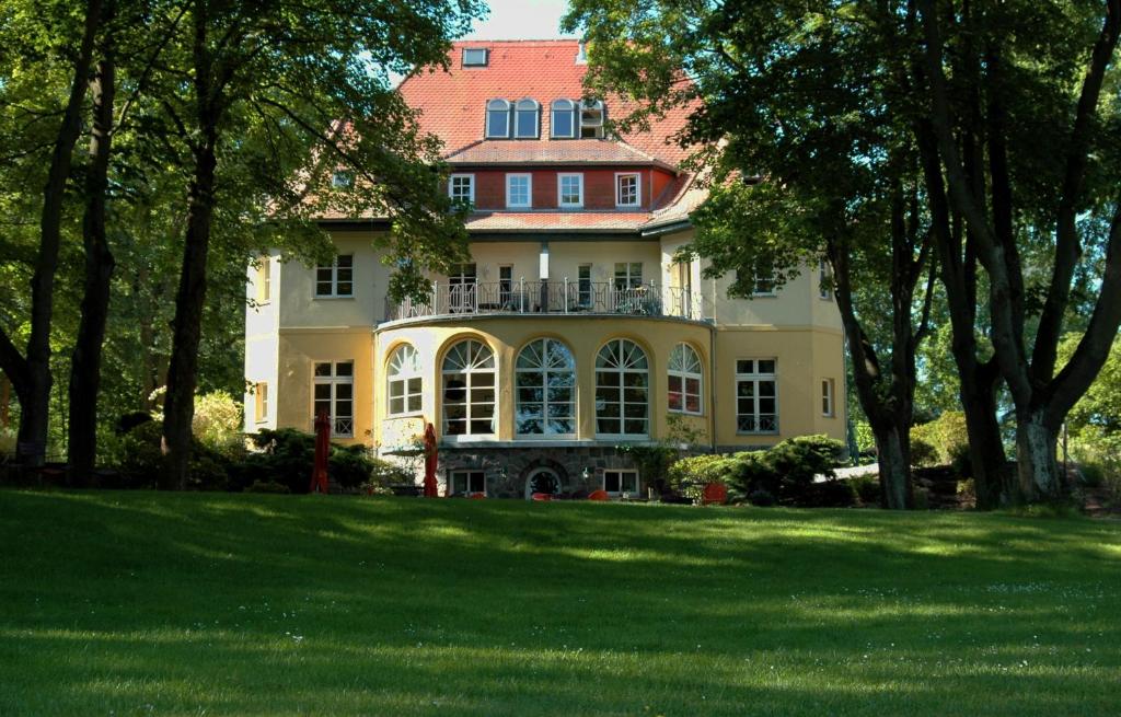 フュルステンベルク・ハーヴェルにあるLandhaus Himmelpfort am Seeの木の植わる広い庭のある大きな家