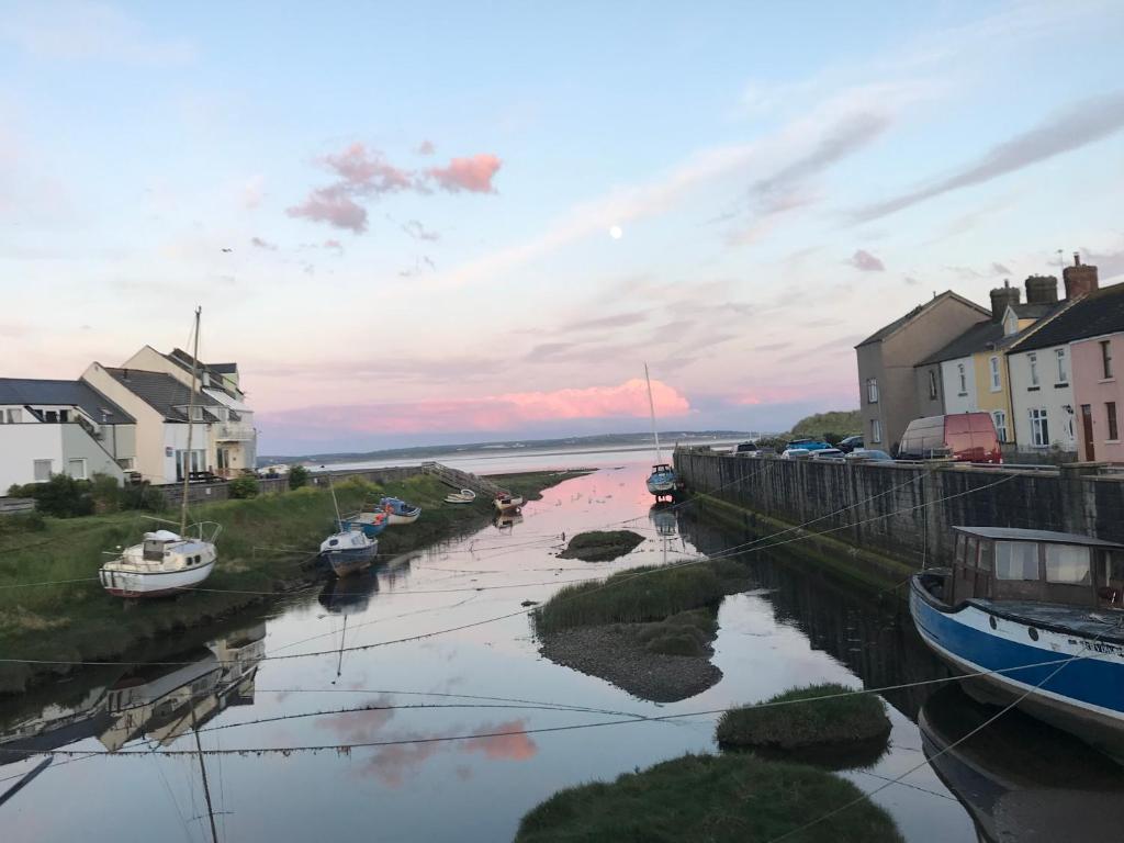 a river with boats in the water and houses at Combe-n-Sea in Haverigg