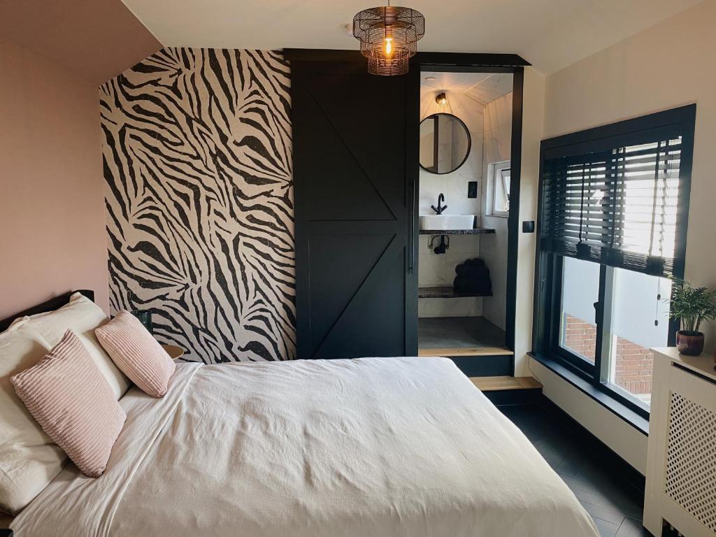 una camera da letto con un letto con una parete a stampa zebra di Kavel 90 a Den Burg