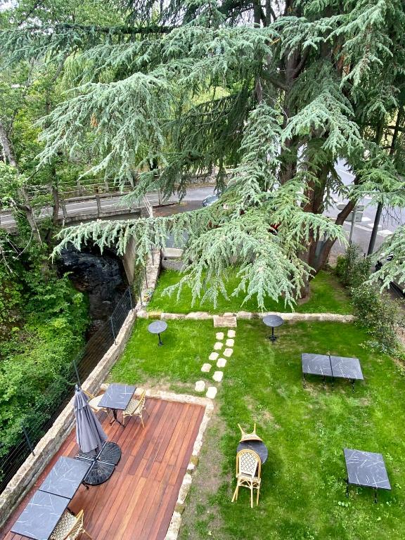 - une vue aérienne sur un jardin avec des tables et des chaises dans l'établissement Le Courancon, à Saint-Nectaire