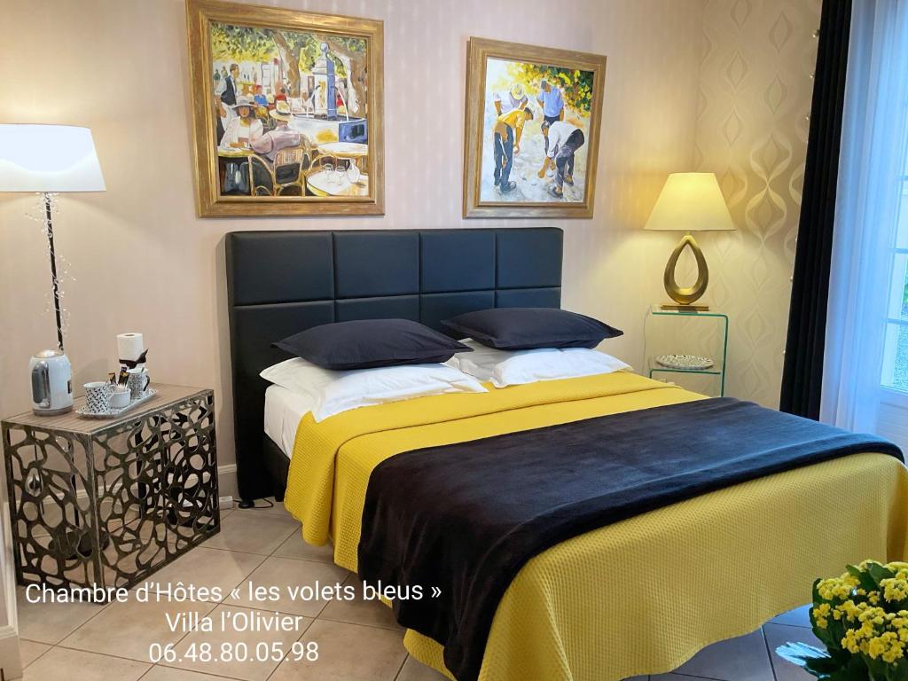 a bedroom with a large bed with a yellow blanket at CHAMBRE D'HOTES "Les Volets Bleus" - VILLA L'OLIVIER côté mer in Vaux-sur-Mer