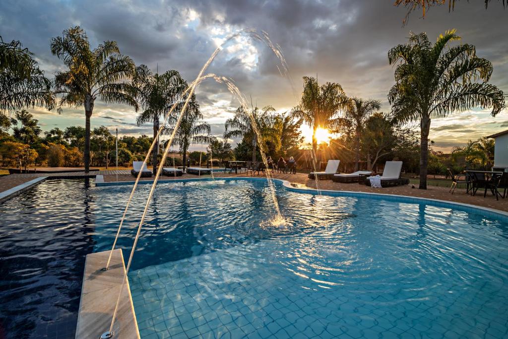 a swimming pool with a fountain in a resort at Pousada Pé na Terra in Brotas