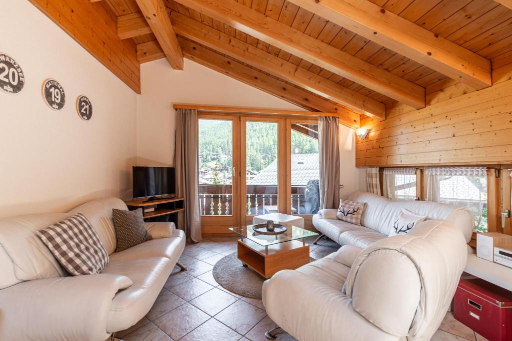 uma sala de estar com dois sofás e uma televisão em Dachwohnung Balma-great overview of Zermatt em Zermatt