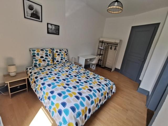 um quarto com uma cama com um edredão colorido em STAY IN MULHOUSE em Mulhouse