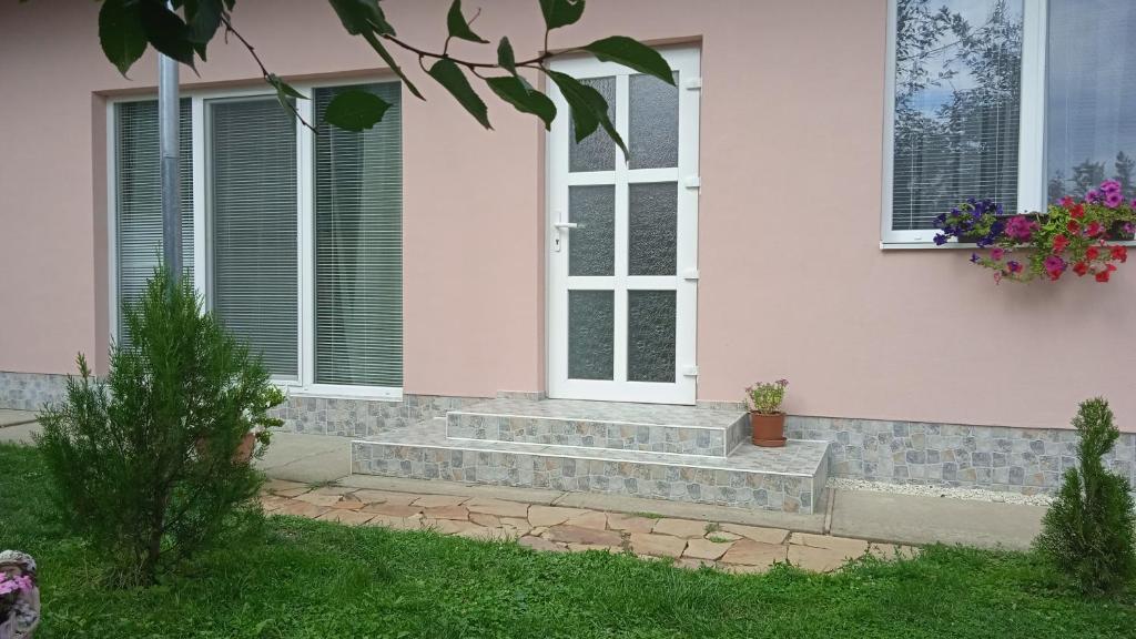 a pink house with stairs and windows on it at Будинок для відпочинку Dana in Berehove