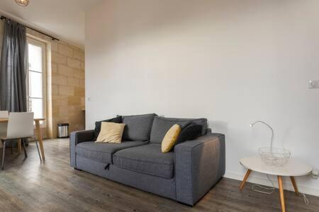 a living room with a gray couch and a table at Appartement De Lerme in Bordeaux