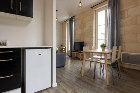 a kitchen and dining room with a table and chairs at Appartement De Lerme in Bordeaux
