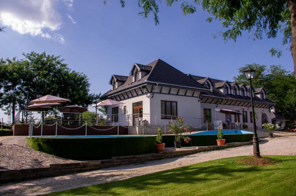 a large white house with a black roof at Reneszánsz Vendégház in Debrecen