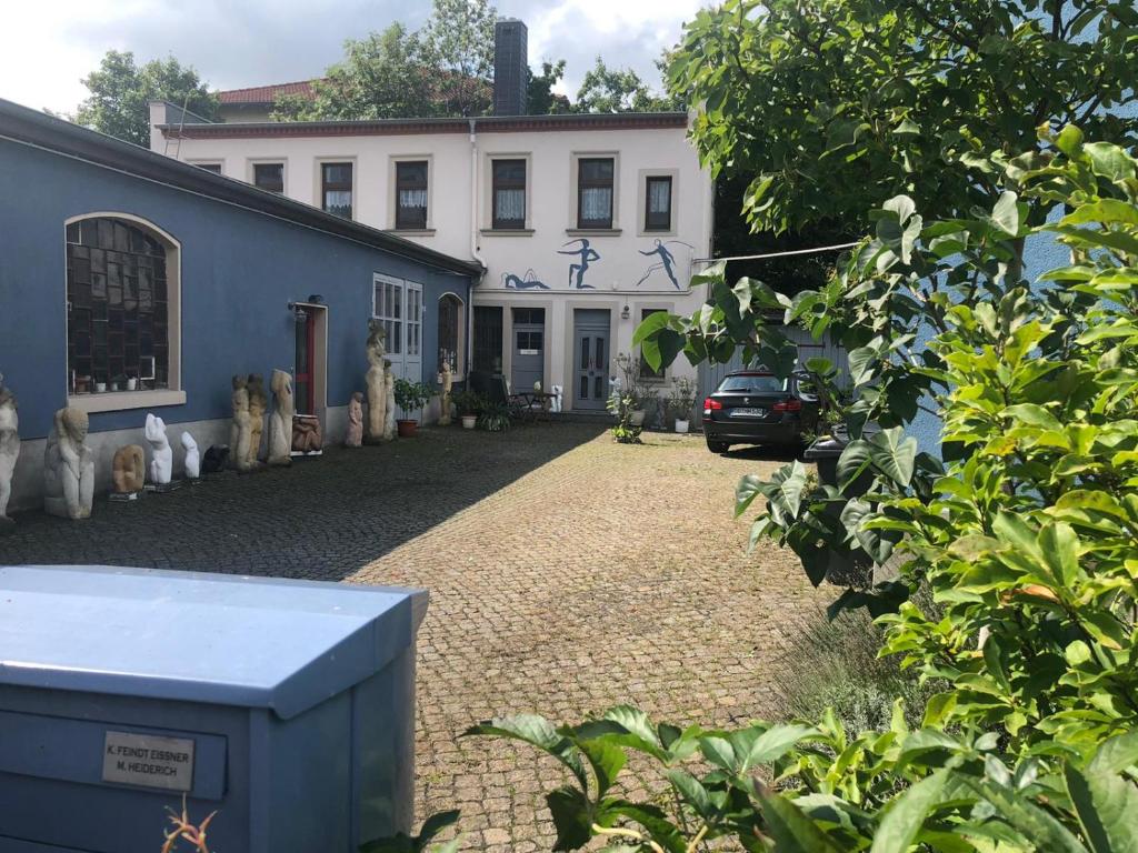 ein großes weißes Haus mit einem davor geparkt in der Unterkunft Kunstoase am blauen Haus in Dresden