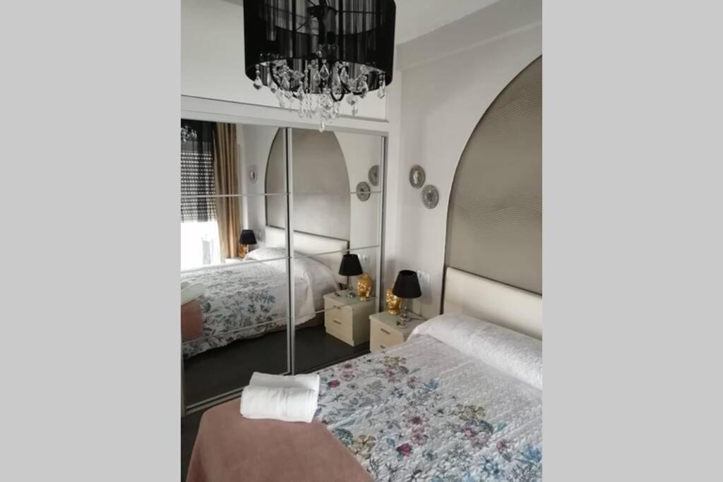 um quarto com 2 camas e um lustre em Luminoso Loft em Monforte de Lemos
