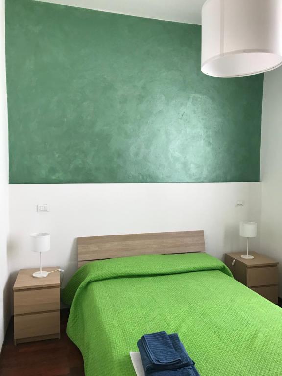um quarto com uma cama verde e um quadro negro verde em affittacamere alloggio olivo em Empoli