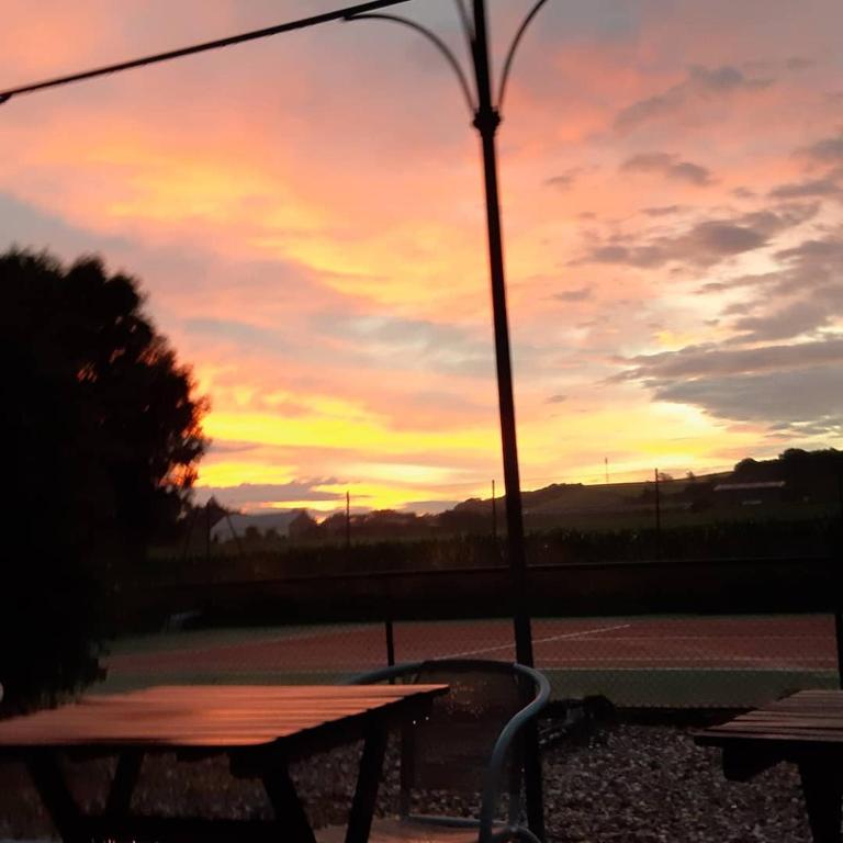 - un coucher de soleil avec une table de pique-nique et une lampe de rue dans l'établissement Relais saint vincent, à Thonville