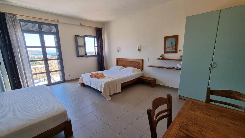 a hotel room with a bed and a window at Domatia me Thea in Elafonisos